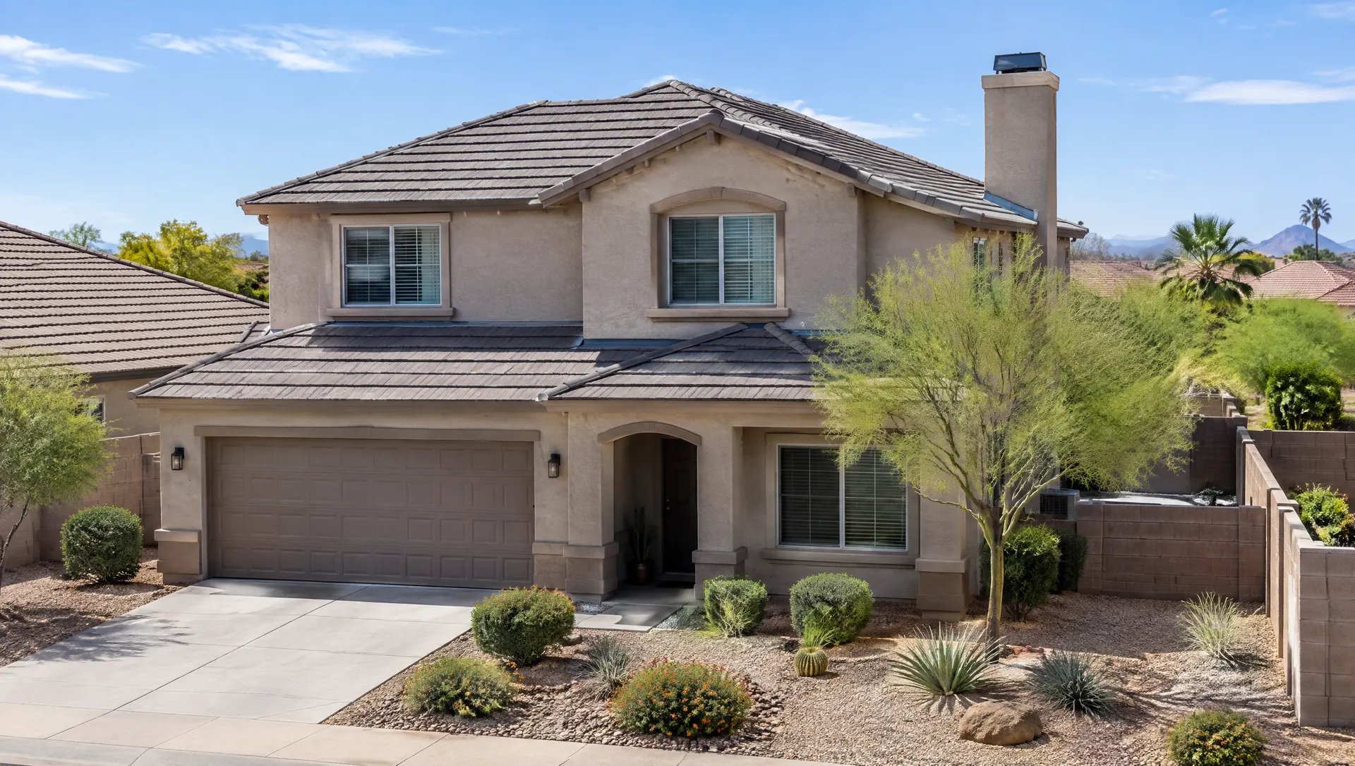 Two-story stucco home in a Chandler subdivision with a brand new roof, clean ridge and hip lines, fresh flashing at the chimney chase, desert landscaping and a block wall